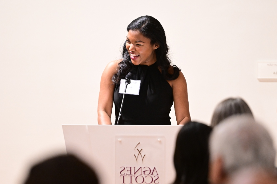 A woman smiles at a podium